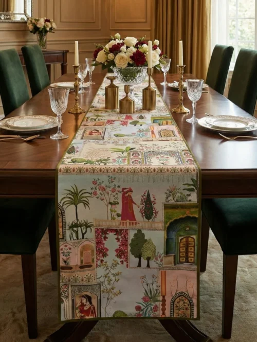 Mughal courtyard panel table runner placed on a wooden dining table with upholstered green chairs